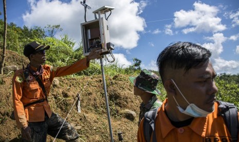 Sejumlah petugas SAR gabungan memeriksa alat pendeteksi getaran atau Elwasi (Eling Waspada Lan Siaga) di puncak area tanah longsor, Desa Sirnaresmi, Cisolok, Kabupaten Sukabumi, Jawa Barat, Jumat (4/1/2019).