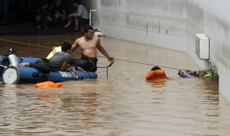 Sejumlah petugas Search And Rescue (SAR) melakukan pencarian sejumlah korban yang diduga terjebak banjir di area parkir bawah tanah (basement) yang terendam banjir di Plaza UOB, Jakarta Pusat, Jumat (18/1/2013)