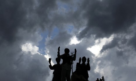     Sejumlah peziarah berdoa di puncak gunung Jabal Nur yang berlokasi di luar kota Makkah, Ahad (21/10).   (Hassan Ammar/AP)