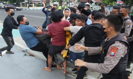 Sejumlah polisi berusaha mengamankan mahasisiswa yang melakukan aksi unjukrasa sambil membakar ban bekas di depan gedung DPRD Kabupaten Jombang, Jawa Timur, Kamis (1/9/2022). Aksi ujukrasa yang menolak rencana kenaikan bahan bakar minyak (BBM) tersebut berlangsung ricuh. 