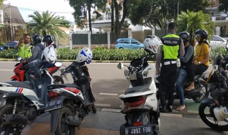 Sejumlah Polisi lalu lintas menggelar razia lalu lintas pengendara roda dua di perempatan jalan Imam Bonjol, Menteng, Jakarta Pusat, Sabtu (16/3). Anehnya, tidak semua diberhentikan. 