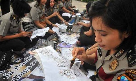  Sejumlah polisi wanita jajaran Polrestabes Surabaya, membuat batik tulis di Taman Bungkul, Surabaya, Jatim, Senin (1/10). 