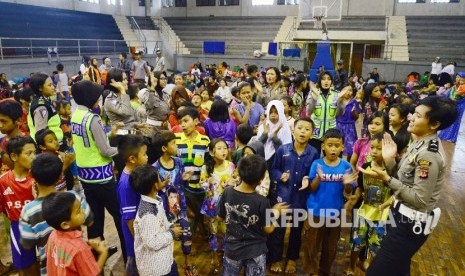 Sejumlah polwan menghibur anak-anak di tempat pengungsian korban longsor, di GOR Tadjimalela, Kabupaten Sumedang, Rabu (21/9)