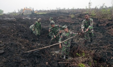  Sejumlah prajurit Kostrad menyelesaikan pembuatan embung penampung air di lahan gambut bekas kebakaran di Desa Rimbo Panjang Kabupaten Kampar, Riau, Jumat (9/10).