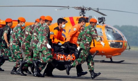 Sejumlah prajurit Paskhas TNI AU dan personil Basarnas membawa sebuah kantong yang berisi jenazah korban kecelakaan pesawat Sukhoi Super Jet 100 menuju mobil ambulance di Bandara Halim Perdanakusuma, Jakarta, Sabtu (12/5). Empat kantong jenazah telah berad