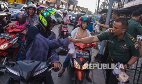 Sejumlah prajurit TNI AD dari Korem 031/Wira Bima membagikan takjil kepada warga di Kota Pekanbaru, Riau, Rabu (8/5/2019).