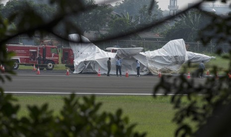 Sejumlah prajurit TNI AU berjaga di dekat badan pesawat tempur F16 yang ditutupi terpal di ujung landasan pacu Pangkalan Udara Halim Perdanakusuma, Jakarta Timur, Kamis (16/4).  (ANTARA/Widodo S. Jusuf).