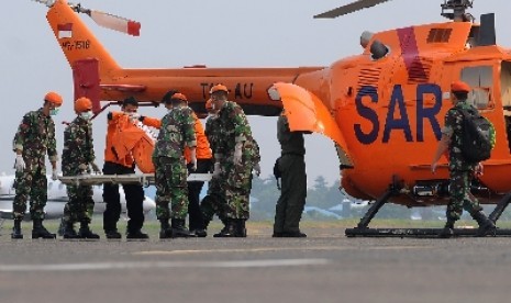 Sejumlah prajurit TNI AU, personil Basarnas dan PMI mengangkat kantong jenazah korban kecelakaan pesawat Sukhoi Super Jet 100 di Bandara Halim Perdanakusuma, Jakarta, Sabtu (12/5). 