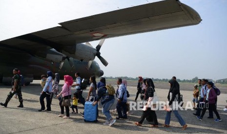 Sejumlah prajurit TNI dan keluarga berjalan menuju pesawat Hercules sesaat sebelum lepas landas di Lanud Halim Perdanakusuma, Jakarta Timur, Sabtu (1/6).