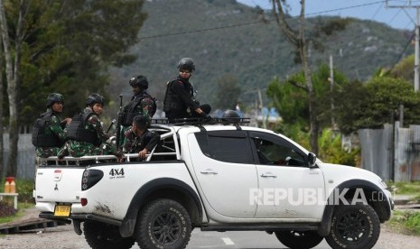 Sejumlah prajurit TNI dan Polri melakukan patroli dengan menaiki mobil bak terbuka ketika melintas di Jalan Trans-Papua Pikhe, Kota Wamena, Kabupaten Jayawijaya, Rabu (9/10/2019). 