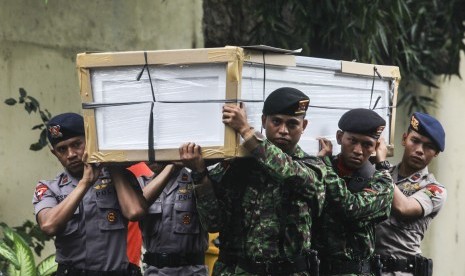 Sejumlah prajurit TNI dan Polri mengangkat peti Jenazah di RS Polri, Jakarta, Senin (21/3). Sebanyak 13 peti jenazah tersebut akan digunakan untuk menyemayamkan jenazah korban kecelakaan helikopter BELL 412 nomor HA 5171 milik TNI di Desa Kasiguncu, Poso P