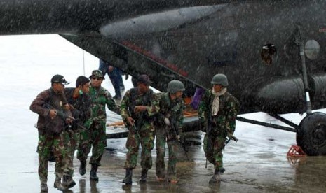 Sejumlah prajurit TNI memapah rekan mereka yang menjadi korban penembakan dan penyergapan kelompok sipil bersenjata setibanya di Bandara Sentani, Kabupaten Jayapura, Papua, Ahad (24/2).