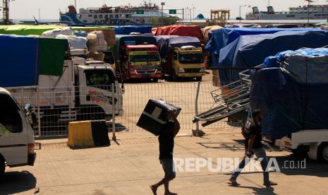 Sejumlah pria berjalan di antara truk pembawa logistik antarpulau di NTT di pelabuhan Angkutan Sungai, Danau dan Penyeberangan (ASDP) Indonesia Ferri di Bolok, Kupang, NTT (4/6/2020). Sebanyak 30 truk pengangkut logistik dan sembako ke sejumlah pulau di NTT tertahan di pelabuhan tersebut akibat adanya pembatasan 50 persen kapasitas angkutan kapal guna mencegah penyebaran COVID-19. 