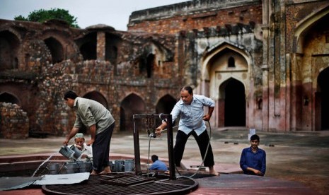 Sejumlah pria menimba air dari sumur untuk kebutuhan wudhu jamaah sebelum shalat Jumat pertama Ramadhan di masjid peninggalan era Mughal, New Delhi, India,