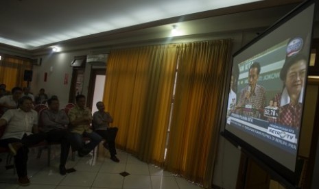 Sejumlah relawan dan anggota tim pemenangan menyaksikkan hasil quick count Pemilu Presiden 2014 melalui layar lebar di Posko Pemenangan Jokowi-JK, Jl Cemara 19, Menteng, Jakarta, Rabu (9/7). 