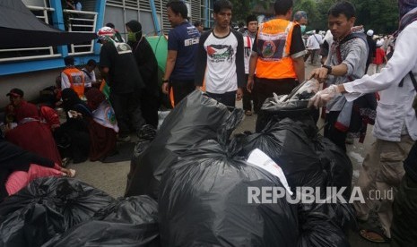 Sejumlah relawan dari komunitas pendaki muslim menata sampah yang telah mereka kumpulkan pada aksi bela Palestina di Monas,Jakarta, Ahad (17/12)