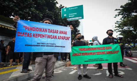 Sejumlah relawan membentangkan spanduk saat rencana pengosongan aset di SDN Pondok Cina 1, Depok, Jawa Barat.