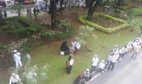 Sejumlah relawan memunguti sisa sampah di taman kota saat aksi damai Bela Islam, Jumat (4/11).