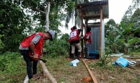 Sejumlah relawan Palang Merah Indonesia (PMI) Provinsi Maluku membangun sarana Mandi, Cuci dan Kakus (MCK) darurat bagi para pengungsi korban gempa bumi di lokasi pengungsian Desa Waai, Pulau Ambon, Kecamatan Salahutu, Kabupaten Maluku Tengah, Maluku, Sabtu (5/10). 