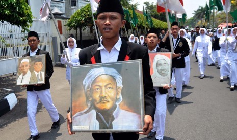 Sejumlah santri membawa foto-foto tokoh alim ulama NU (Nahdlatul Ulama) saat mengikuti kirab santri dalam rangka Hari Santri Nasional di Kota Temanggung, Jateng, Kamis (22/10).