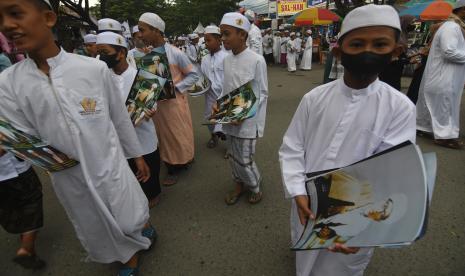 Sejumlah santri membawa poster Sayyid Idrus bin Salim Aljufri atau Guru Tua pada peringatan Haul Guru Tua di Kompleks Alkhairaat di Palu, Sulawesi Tengah, Sabtu (14/5/2022). Pemerintah setempat mengusulkan Guru Tua yang merupakan pendiri Alkhairaat sekaligus tokoh penyebaran agama dan pendidikan Islam di Sulawesi Tengah dan Kawasan Timur Indonesia tersebut menjadi pahlawan nasional. 