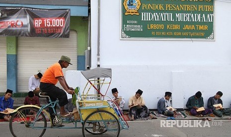 Sejumlah santri mengaji kitab kuning (kitab klasik berbahasa arab gundul) di komplek pondok pesantren (ponpes) Lirboyo, Kota Kediri, Jawa Timur. Pegiat media sosial Eko Kuntadhi disebut akan mengunjungi Lirboyo setelah muncul cicitannya yang diduga menghina ustazah Ning Imaz.