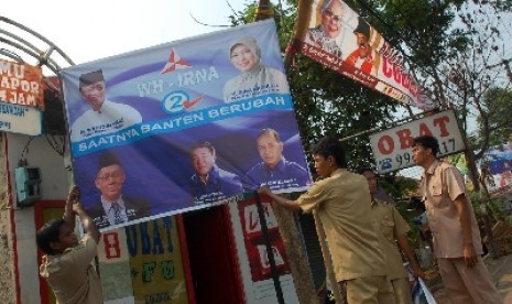 Sejumlah satpol PP menertibkan atribut kampanye Pilgub yang dianggap melanggar Perda K3 di sejumlah jalan protokol di kawasan Tangerang, Banten, Selasa (11/10). Beragam atribut kampanye mulai dari baliho, spanduk yang dianggap melanggar kebersihan, keterti