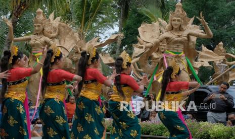 Sejumlah seniman menari di dekat patung sembilan bidadari berbahan anyaman bambu yang dipajang saat rangkaian pawai di Alas Harum Bali, Desa Tegallalang, Gianyar, Bali, Ahad (13/3/2022). Pawai tersebut untuk menyambut kebijakan kunjungan wisatawan mancanegara tanpa karantina di Bali sekaligus sebagai daya tarik pariwisata.