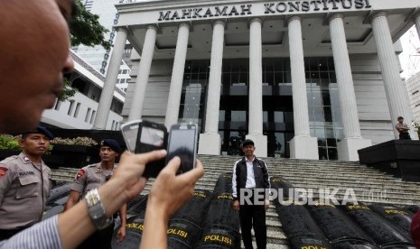 Sejumlah simpatisan asal daerah berfoto didepan gedung Mahkakamah Konstitusi (MK) saat berlangsungnya sidang panel lanjutan perselisihan hasil pemilihan (PHP) kepala daerah 2015 di Gedung Mahkamah Konstitusi, Jakarta, Kamis (21/1).