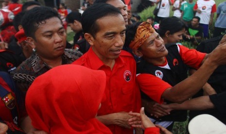   Sejumlah simpatisan berebut bersalaman dengan calon Presiden Joko Widodo, saat mengikuti kampanye PDIP di Lapangan Mulyorejo, Malang, Jawa Timur, Ahad (30/3).