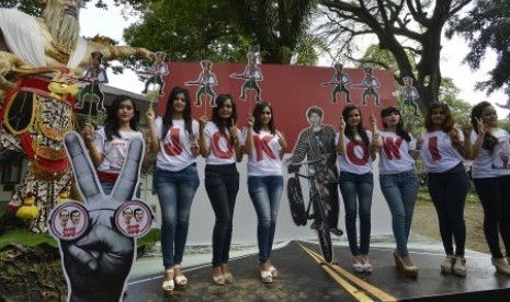 Sejumlah simpatisan berpose menggunakan atribut kampanye dari calon presiden pasangan nomor urut dua, Joko Widodo di Taman Balekambang, Surakarta, Jawa Tengah, Jumat (20/6). 