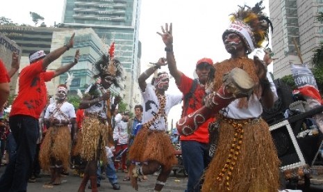 Sejumlah simpatisan yang tergabung dalam Komunitas Relawan Peduli Papua Bangkit dan Barisan Relawan Jokowi Presiden menari bersama saat melakukan aksi dukungan kepada Gubernur DKI Jakarta Joko Widodo di kawasan bundaran HI, Jakarta Pusat, Ahad (11/5).