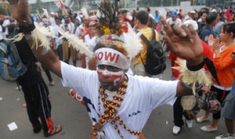 Sejumlah simpatisan yang tergabung dalam Komunitas Relawan Peduli Papua Bangkit dan Barisan Relawan Jokowi Presiden menari bersama saat melakukan aksi dukungan kepada Gubernur DKI Jakarta Joko Widodo di kawasan bundaran HI, Jakarta Pusat, Ahad (11/5).