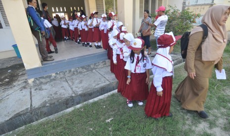 Sejumlah siswa dan siswi peserta didik baru diajak berkeliling untuk mengenal lingkungan pada hari pertama masuk sekolah di SDN Madani, Palu, Sulawesi Tengah, Senin (9/7). Seluruh siswa SD, SMP, SMA/SMK dan sederajatnya setempat mulai masuk kembali bersekolah pada tahun ajaran baru 2018/2019.