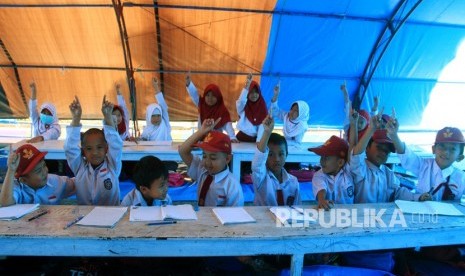 Belajar bisa dimana saja salah satu yang ditanamkan dalam merdeka belajar. Foto sejumlah siswa dan siswi sekolah dasar mengikuti proses belajar di tenda pengungsian sementara. (ilustrasi)