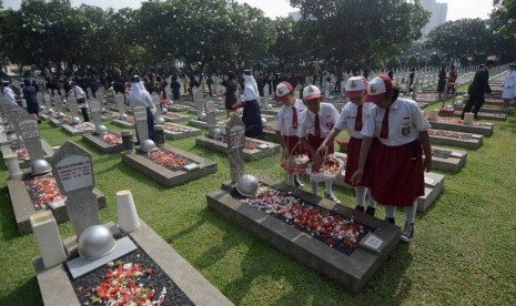    Sejumlah siswa melakukan tabur bunga ke sejumlah makam pahlawan usai Upacara Ziarah Nasional di Taman Makam Pahlawan Nasional, Kalibata, Jakarta, Senin (10/11). (Republika/Agung Supriyanto)