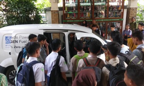 Sejumlah siswa melihat contoh mobil dengan energi hidrogen yang dipamerikan di Surabaya, Rabu (13/3).