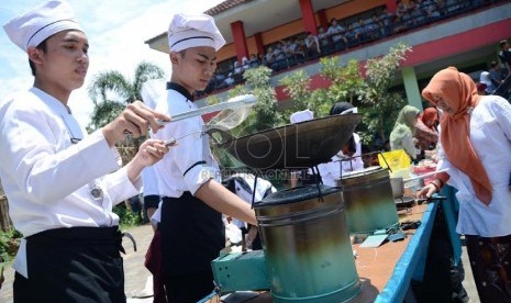 Sejumlah siswa SMKN 9 memasak dengan menggunakan Kompor Sakti karya siswa SMKN 2 Bandung, Kamis (31/10).    (Republika/Edi Yusuf)