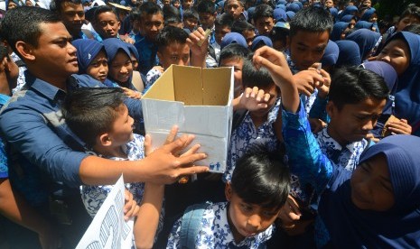 Sejumlah siswa memasukkan uang ke dalam kotak pada aksi penggalangan dana untuk korban gempa Aceh di SMP Negeri 10 Kota Tasikmalaya, Jawa Barat, Kamis (8/12).