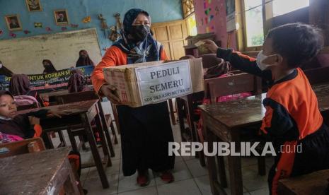 Sejumlah siswa memasukkan uang saat penggalangan dana untuk warga terdampak erupsi Gunung Semeru di SDN Denasri Wetan 02, Kabupaten Batang, Jawa Tengah, Jumat (10/12/2021). Penggalangan dana itu diadakan untuk melatih siswa dalam meningkatkan rasa saling tolong menolong dan solidaritas sesama manusia dan membantu meringankan warga terdampak erupsi Gunung Semeru di Lumajang, Jawa Timur. 