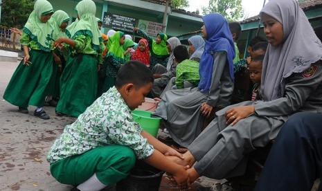 Sejumlah siswa membasuh kaki ibu guru mereka di Madrasah Ibtidaiyah (MI) Canden, Sambi, Boyolali, Jawa Tengah, Rabu (25/11).