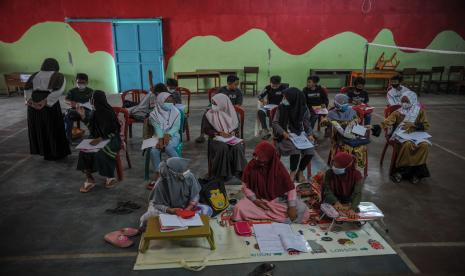 Sejumlah siswa menerima materi asesmen kompetensi minimum kepada siswa SDN Hegarmanah di sebuah GOR bulutangkis di Tanjungsari, Kabupaten Sumedang, Jawa Barat, Rabu (22/9/2021). Pemberian materi tersebut ditujukan untuk persiapan menghadapi asesmen nasional yang dilaksanakan untuk pemetaan pendidikan di Indonesia.