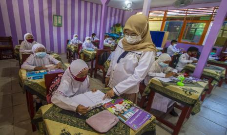 Sejumlah siswa menerima materi dari guru di SD Negeri Karang Mekar 5, Banjarmasin, Kalimantan Selatan, Senin (20/9/2021). Pemerintah Kota Banjarmasin melalui Dinas Pendidikan Kota Banjarmasin kembali melaksanakan Pembelajaran Tatap Muka (PTM) untuk semua jenjang pendidikan yakni Pendidikan Anak Usia Dini (PAUD), Sekolah Dasar (SD) dan Sekolah Menengah Pertama (SMP) setelah mendapat izin atau rekomendasi dari Satgas COVID-19 Banjarmasin serta mempertimbangkan Surat Keputusan Bersama (SKB) empat menteri dengan penerapan disiplin protokol kesehatan yang ketat.