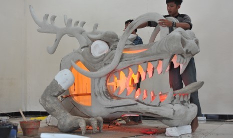 Sejumlah siswa mengerjakan rangka kepala naga yang akan digelar pada festival budaya sebagai rangkaian acara Gerhana Matahari Total (GMT) di bengkel SMK Negeri 7 Palembang, Sumatera Selatan, Kamis (25/2). 