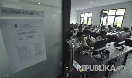 Sejumlah siswa mengerjakan soal Bahasa Indonesia saat mengikuti Ujian Nasional Berbaris Komputer (UNBK) di SMKN 2 Bandung, Jalan Ciliwung, Kota Bandung, Senin (3/4).