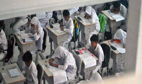 Sejumlah siswa mengerjakan soal Ujian Nasional SD mata pelajaran Bahasa Indonesia di SD Insan Kamil, jalan raya Dramaga, Bogor, Jawa Barat, Senin (16/5). 