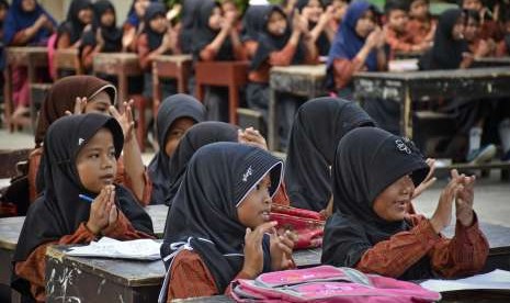 Sejumlah siswa mengikuti kegiatan belajar mengajar diluar ruangan sekolah pascagempa di SDN 2 Gunungsari, Kecamatan Gunungsari, Lombok Barat, NTB, Rabu (29/8). 