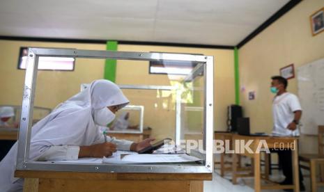 Sejumlah siswa mengikuti pelajaran tatap muka di Madrasah Tsanawiyah (MTs) Al Mujahidin Kabila, Kabupaten Bone Bolango, Gorontalo. Pemerintah pusat memberikan kewenangan ke pemerintah daerah untuk menentukan pembukaan kembali sekolah. Pelajaran tatak muka diizinkan setelah melalui persetujuan tiga pihak mulai Januari 2021.