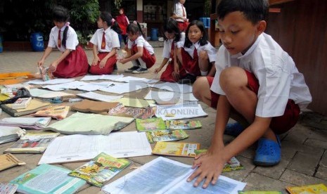  Sejumlah siswa menjemur buku pelajaran yang basah akibat terendam banjir di halaman SDN 02/03 Penjaringan, Jakarta Utara, Senin (28/1). (Repubika/Agung Fatma Putra)