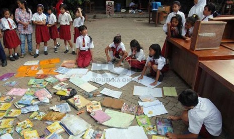  Sejumlah siswa menjemur buku pelajaran yang basah akibat terendam banjir di halaman SDN 02/03 Penjaringan, Jakarta Utara, Senin (28/1). (Repubika/Agung Fatma Putra)